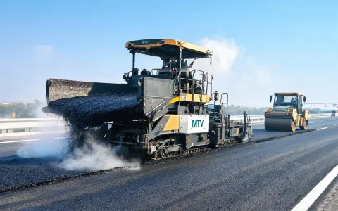 Asphalt paver and rollers on highway